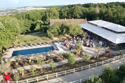 Miniature Photos drone de l'Orangerie de l'Orée du Bois 78 à 45 min de Paris Salle de réception illuminée par des suspensions lumineuses, avec des invités assis à des tables rondes.
