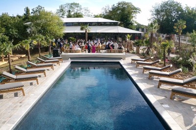Miniature Piscine de l'Orangerie de l'Orée du Bois 78 à rosny sur seine Salle de réception illuminée par des suspensions lumineuses, avec des invités assis à des tables rondes.