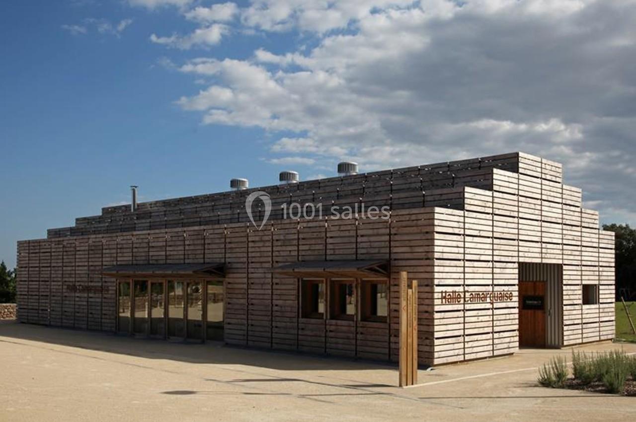Bâtiment en bois à l'architecture moderne, avec un ciel partiellement nuageux en arrière-plan.