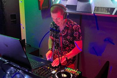 Miniature DJ Agen (Lot-et-Garonne) - Sartomix Dj #8 Un DJ mixe de la musique sur une table de mixage dans un environnement lumineux avec un écran affichant des visuels…