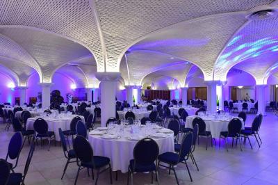 Miniature Location salle Reims (Marne) - Champagne Castelnau - Caveau et Celliers de Réceptions #2 Salle de réception décorée avec des tables rondes, nappes blanches, rubans rouges et tonneaux en arrière-plan.