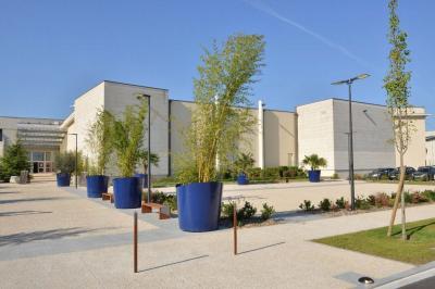 Miniature Location salle Reims (Marne) - Champagne Castelnau - Caveau et Celliers de Réceptions #6 Salle de réception décorée avec des tables rondes, nappes blanches, rubans rouges et tonneaux en arrière-plan.