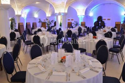 Miniature Location salle Reims (Marne) - Champagne Castelnau - Caveau et Celliers de Réceptions #5 Salle de réception décorée avec des tables rondes, nappes blanches, rubans rouges et tonneaux en arrière-plan.