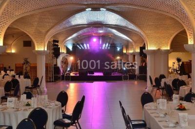 Miniature Location salle Reims (Marne) - Champagne Castelnau - Caveau et Celliers de Réceptions #9 Salle de réception décorée avec des tables rondes, nappes blanches, rubans rouges et tonneaux en arrière-plan.