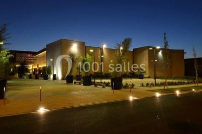 Miniature Location salle Reims (Marne) - Champagne Castelnau - Caveau et Celliers de Réceptions #12 Salle de réception décorée avec des tables rondes, nappes blanches, rubans rouges et tonneaux en arrière-plan.