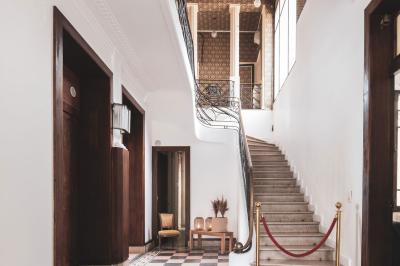 Salle lumineuse décorée pour un événement, avec des tables dressées, des chaises dorées et des fleurs en centre de table.