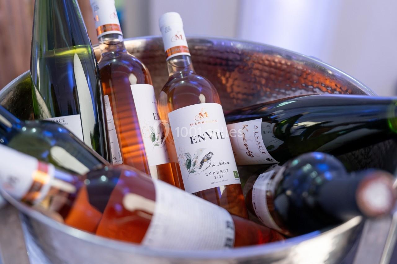 Bouteilles de vin blanc et rosé disposées dans un seau en métal, prêtes à être servies.