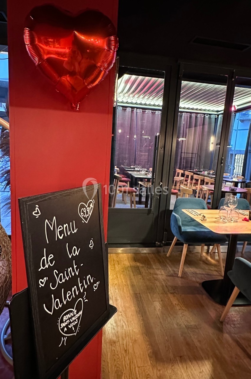 Tableau noir annonçant un menu spécial Saint-Valentin dans un restaurant décoré avec ballon en forme de cœur.