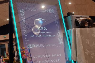 Quatre bandes de photos imprimées montrant des personnes souriantes dans un photomaton, posées sur une surface grise.