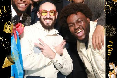 Quatre bandes de photos imprimées montrant des personnes souriantes dans un photomaton, posées sur une surface grise.