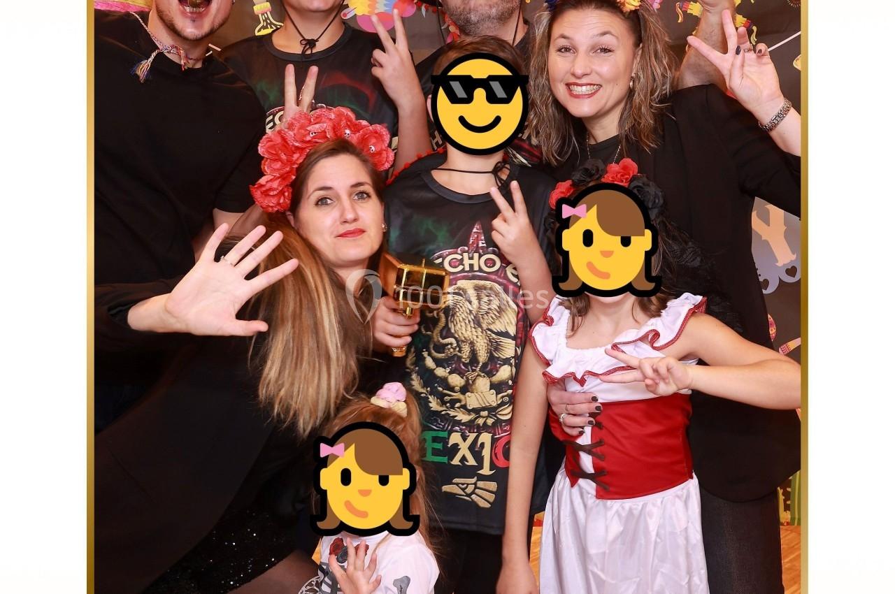 Groupe de personnes déguisées posant joyeusement devant un décor festif lors d'une célébration d'anniversaire.