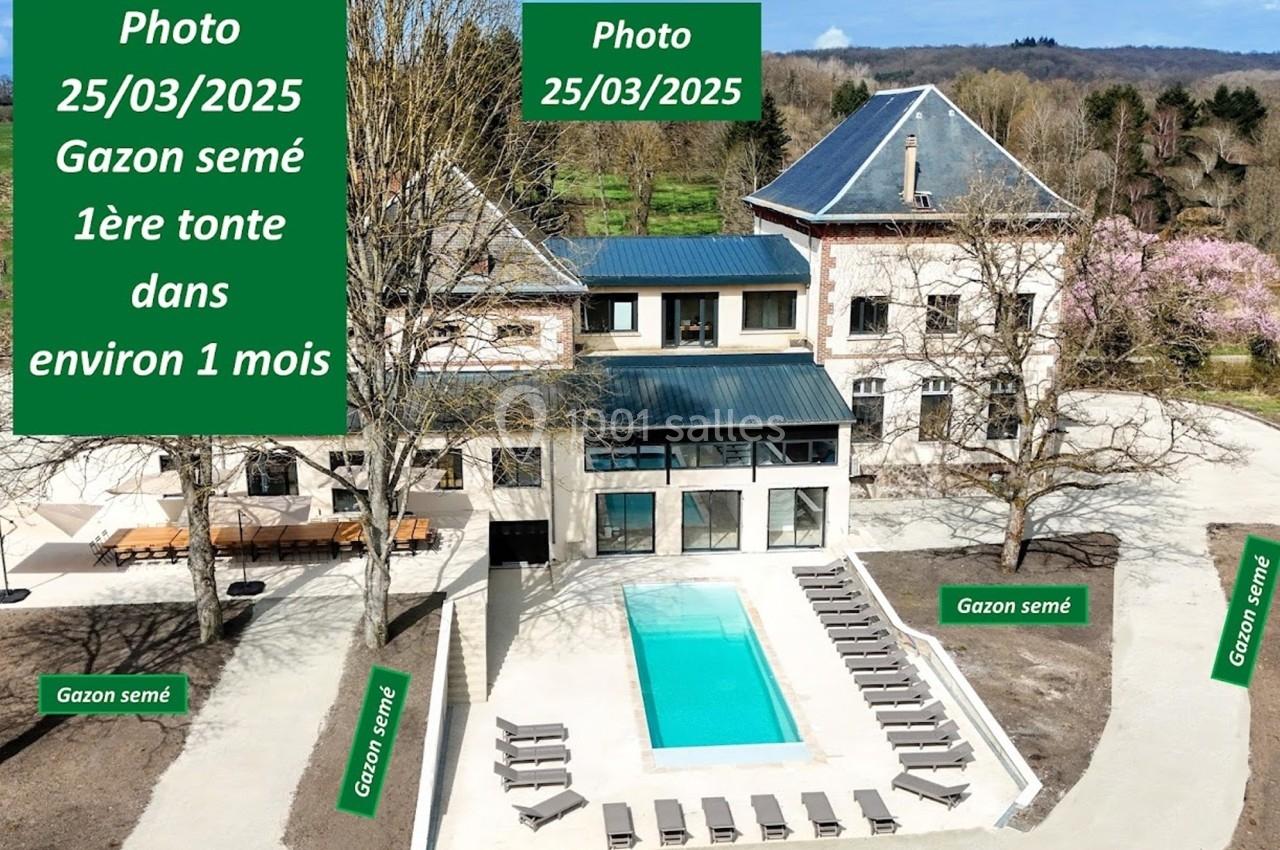 Vue aérienne d'une maison avec piscine, entourée de gazon récemment semé et d'arbres sans feuilles.