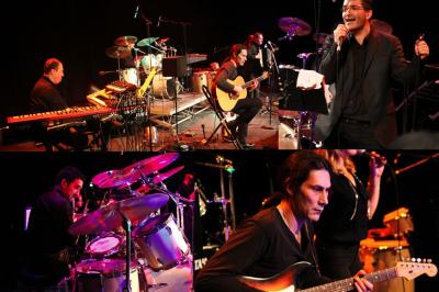 Un batteur joue sur une batterie argentée sur une scène sombre, avec un micro à proximité.