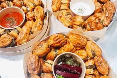 Tranches d'orange garnies de groseilles, pétales de fleurs, amandes effilées et feuilles de menthe dans une assiette.