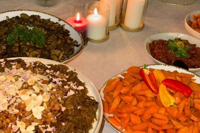 Tranches d'orange garnies de groseilles, pétales de fleurs, amandes effilées et feuilles de menthe dans une assiette.