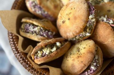 Tranches d'orange garnies de groseilles, pétales de fleurs, amandes effilées et feuilles de menthe dans une assiette.