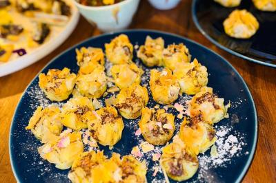 Tranches d'orange garnies de groseilles, pétales de fleurs, amandes effilées et feuilles de menthe dans une assiette.