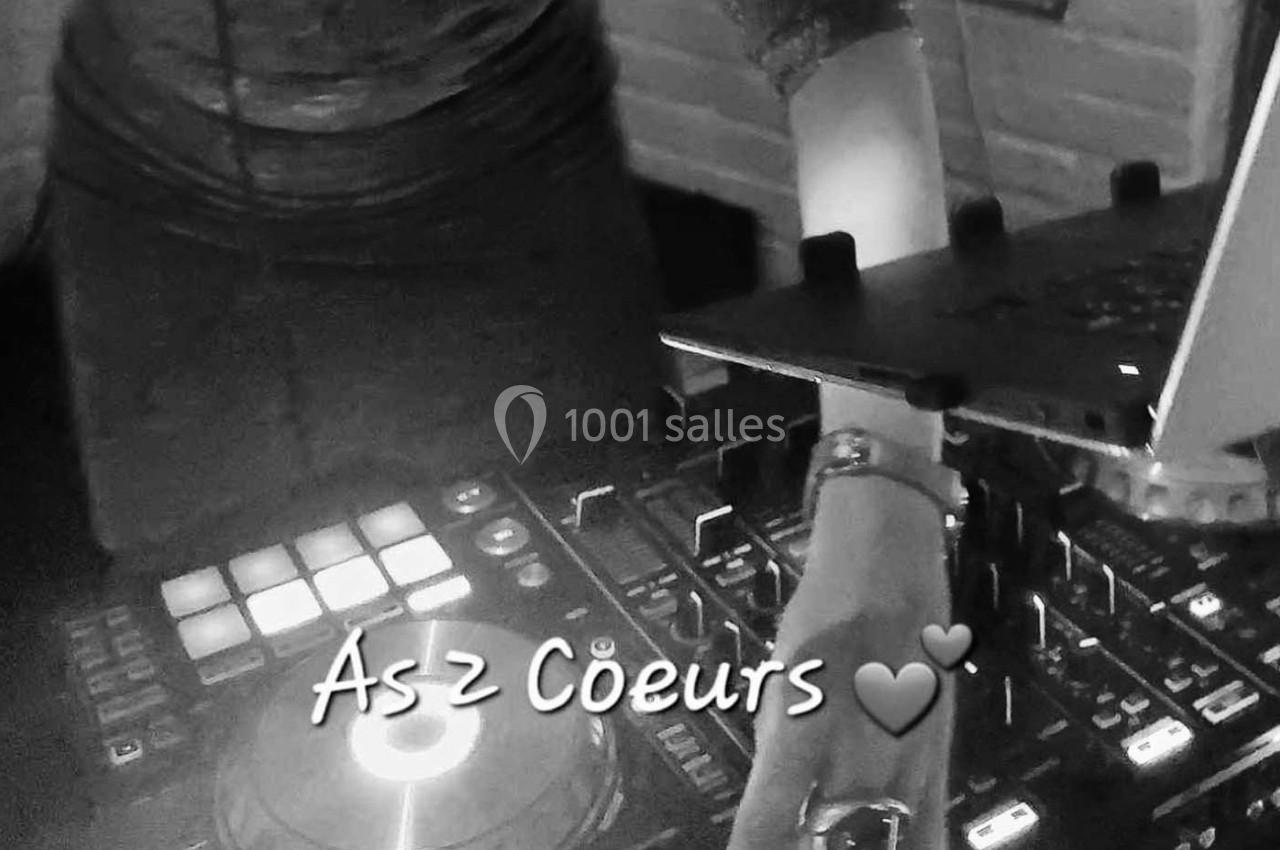 Une personne mixant de la musique sur une table de mixage avec un ordinateur portable à proximité.