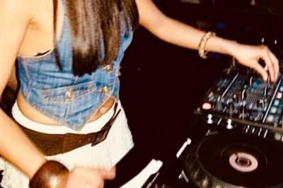 Miniature DJ Saint-Julien-de-Concelles (Loire-Atlantique) - JennyJazz #5 Femme concentrée, portant une robe claire, devant un mur en pierre texturée sous un éclairage violet.