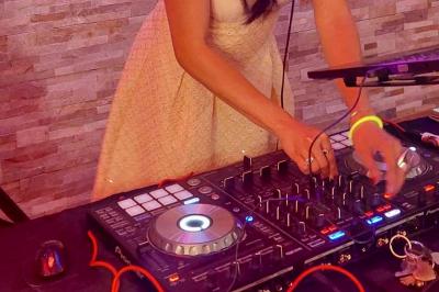 Miniature DJ Saint-Julien-de-Concelles (Loire-Atlantique) - JennyJazz #9 Femme concentrée, portant une robe claire, devant un mur en pierre texturée sous un éclairage violet.