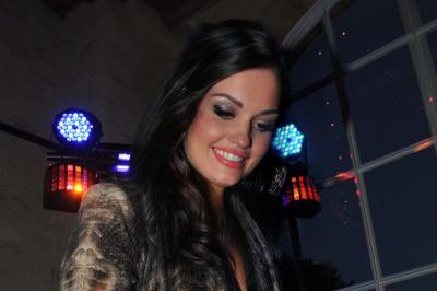 Miniature DJ Saint-Julien-de-Concelles (Loire-Atlantique) - JennyJazz #2 Femme concentrée, portant une robe claire, devant un mur en pierre texturée sous un éclairage violet.