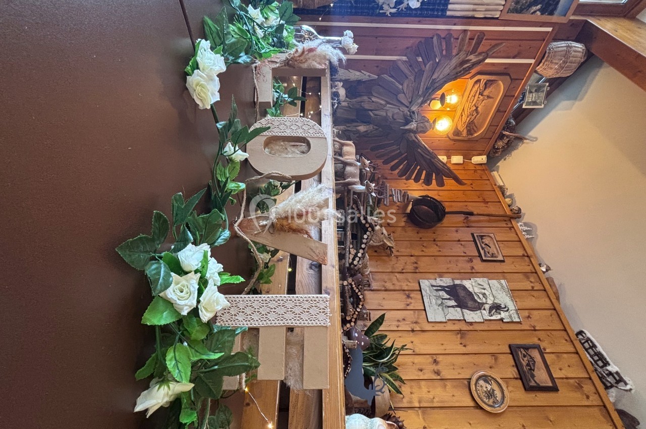 Décoration intérieure en bois avec des fleurs blanches et des éléments naturels dans un cadre rustique.