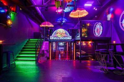 Miniature Location salle Lille (Nord) - Fullmoon #5 Façade d'un bar avec une décoration végétale, des néons roses et des tabourets noirs sur le trottoir.