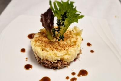 Miniature Traiteur Grigny (Essonne) - LCG Traiteur #67 Plat dressé avec une base de viande effilochée, purée de pommes de terre, feuilles de salade et sauce en décoration.