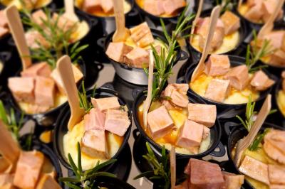 Miniature Cassolette de mignon de porc, jus au romarin et écrasé de pommes de terre à l'huile de truffe Plat dressé avec une base de viande effilochée, purée de pommes de terre, feuilles de salade et sauce en décoration.