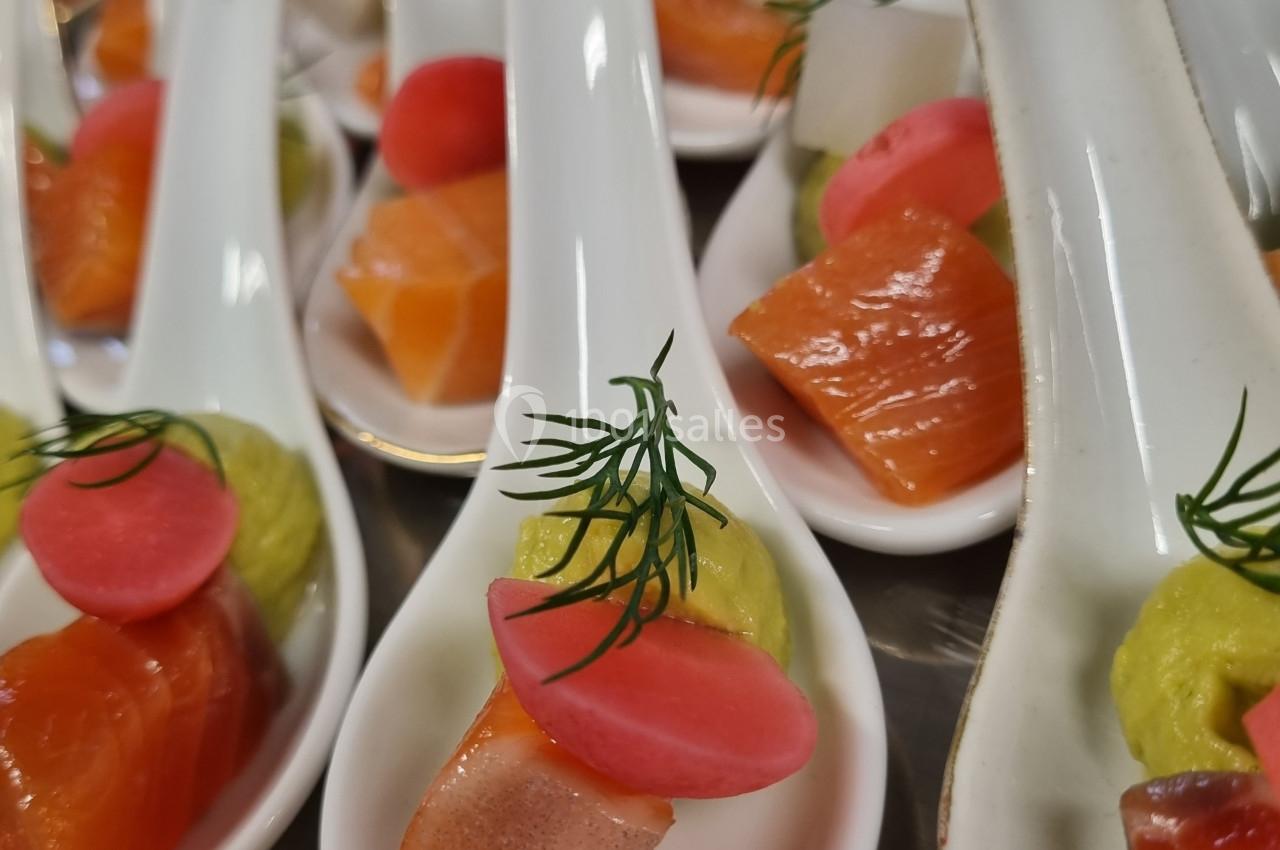Cuillères apéritives garnies de saumon, purée verte, radis rose et brin d'aneth, présentées sur un plateau.