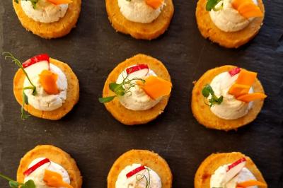 Plat dressé avec une base de viande effilochée, purée de pommes de terre, feuilles de salade et sauce en décoration.