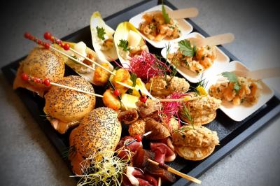 Plat dressé avec une base de viande effilochée, purée de pommes de terre, feuilles de salade et sauce en décoration.