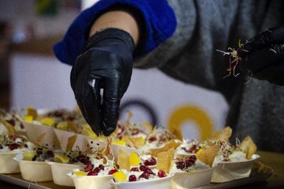 Assiette garnie de falafels dorés entourés de feuilles de salade et accompagnée de pinces en métal.
