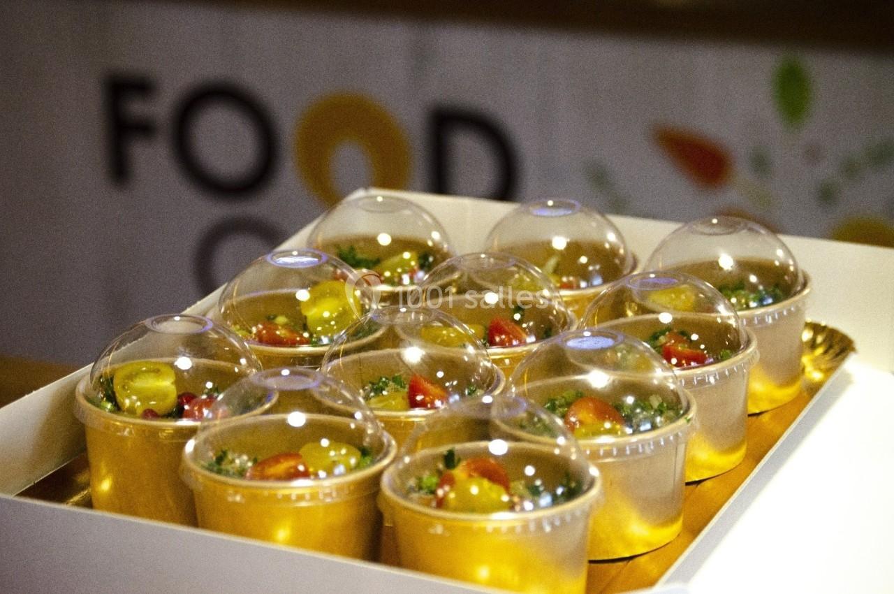 Des verrines remplies de salade colorée, recouvertes de couvercles transparents, disposées dans un plateau blanc.