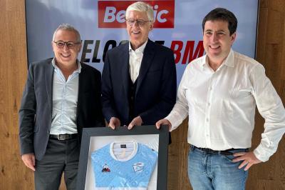 Miniature Les Talents d'Espaces Réceptifs #3 Deux hommes souriants posent à l'extérieur, l'un tenant un skateboard noir et blanc devant un bâtiment moderne.