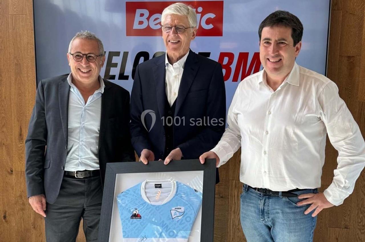 Photo Les Talents d'Espaces Réceptifs #3 Trois hommes posent debout avec un maillot de sport encadré devant un écran affichant ’Beetic’.