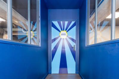 Poste de jeu interactif avec quatre boutons jaunes et un écran affichant ’Quiz Room’ dans un éclairage bleu.