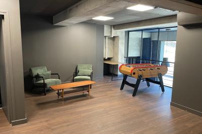 Salle de quiz interactive avec plusieurs bornes équipées d'écrans tactiles et de buzzers jaunes.