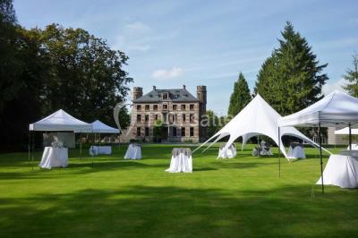 Quatre voitures sportives colorées alignées sur un parking en plein air, entourées de verdure.