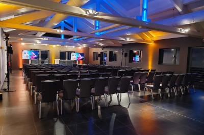 Quatre voitures sportives colorées alignées sur un parking en plein air, entourées de verdure.