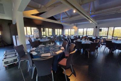 Quatre voitures sportives colorées alignées sur un parking en plein air, entourées de verdure.