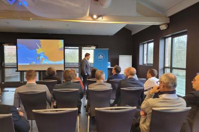 Quatre voitures sportives colorées alignées sur un parking en plein air, entourées de verdure.