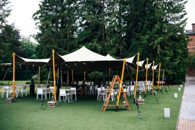 Quatre voitures sportives colorées alignées sur un parking en plein air, entourées de verdure.
