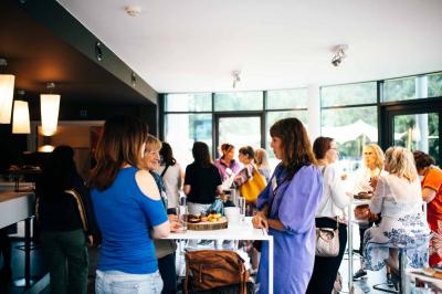Quatre voitures sportives colorées alignées sur un parking en plein air, entourées de verdure.