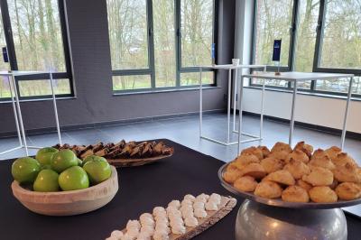 Quatre voitures sportives colorées alignées sur un parking en plein air, entourées de verdure.