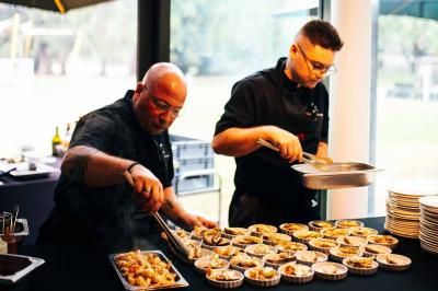 Quatre voitures sportives colorées alignées sur un parking en plein air, entourées de verdure.
