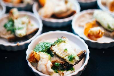 Quatre voitures sportives colorées alignées sur un parking en plein air, entourées de verdure.