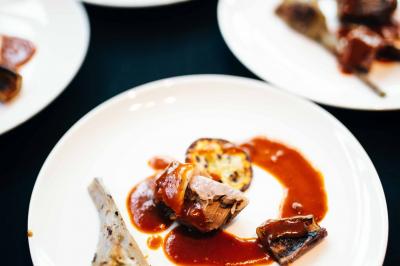 Quatre voitures sportives colorées alignées sur un parking en plein air, entourées de verdure.