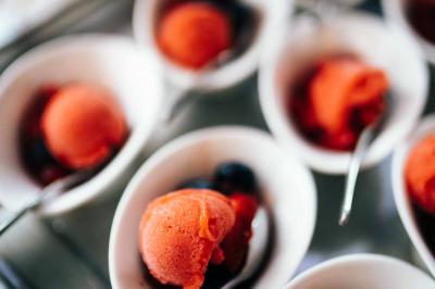 Quatre voitures sportives colorées alignées sur un parking en plein air, entourées de verdure.