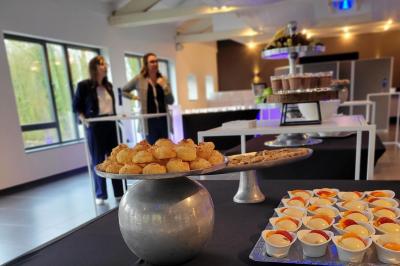 Quatre voitures sportives colorées alignées sur un parking en plein air, entourées de verdure.